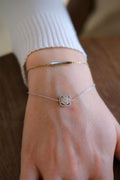 Dainty gold and silver chain bracelets on a wrist