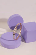 Rose-gold pave hinged bangle on a lilac pedestal