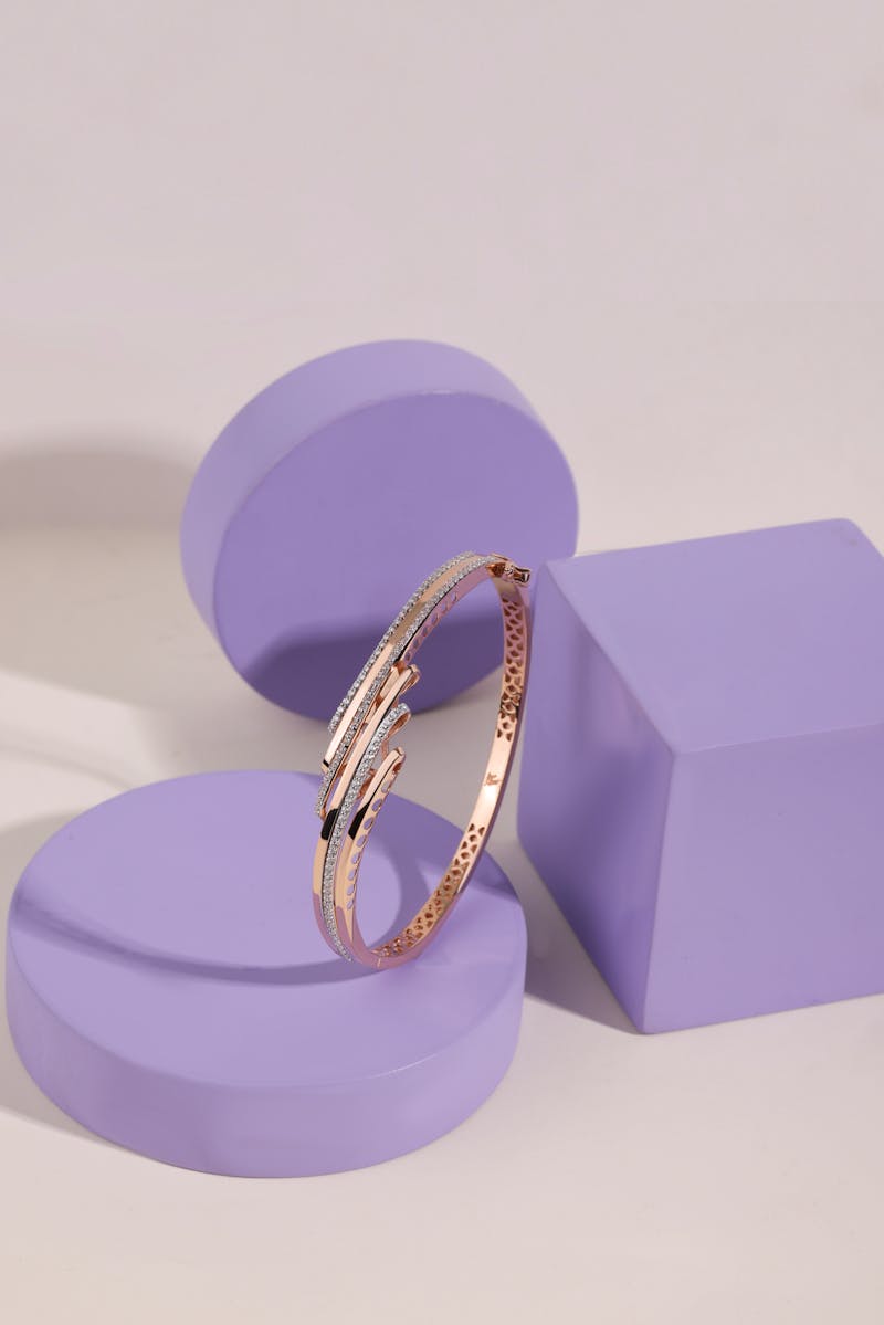 Rose-gold pave hinged bangle on a lilac pedestal