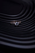 Solitaire engagement ring on rippled black surface