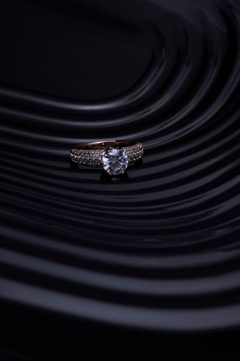 Solitaire engagement ring on rippled black surface