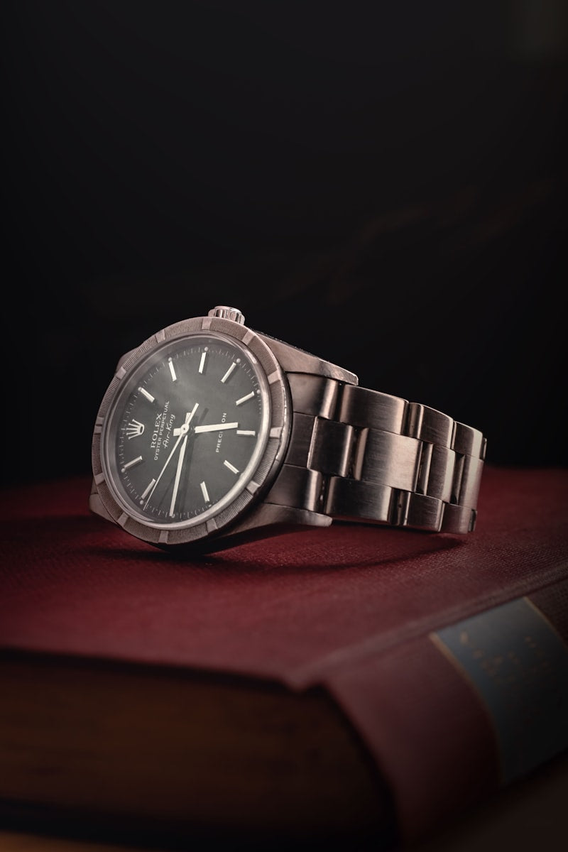 Rose-gold wristwatch with taupe leather strap held in hand