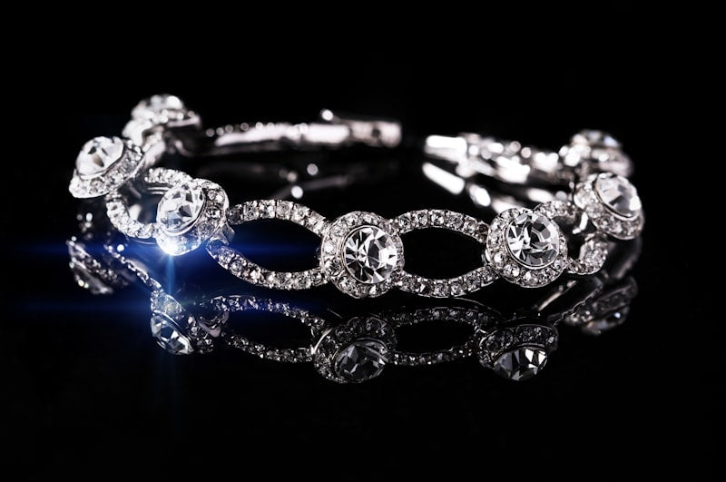 Silver crystal link bracelet on a black reflective surface