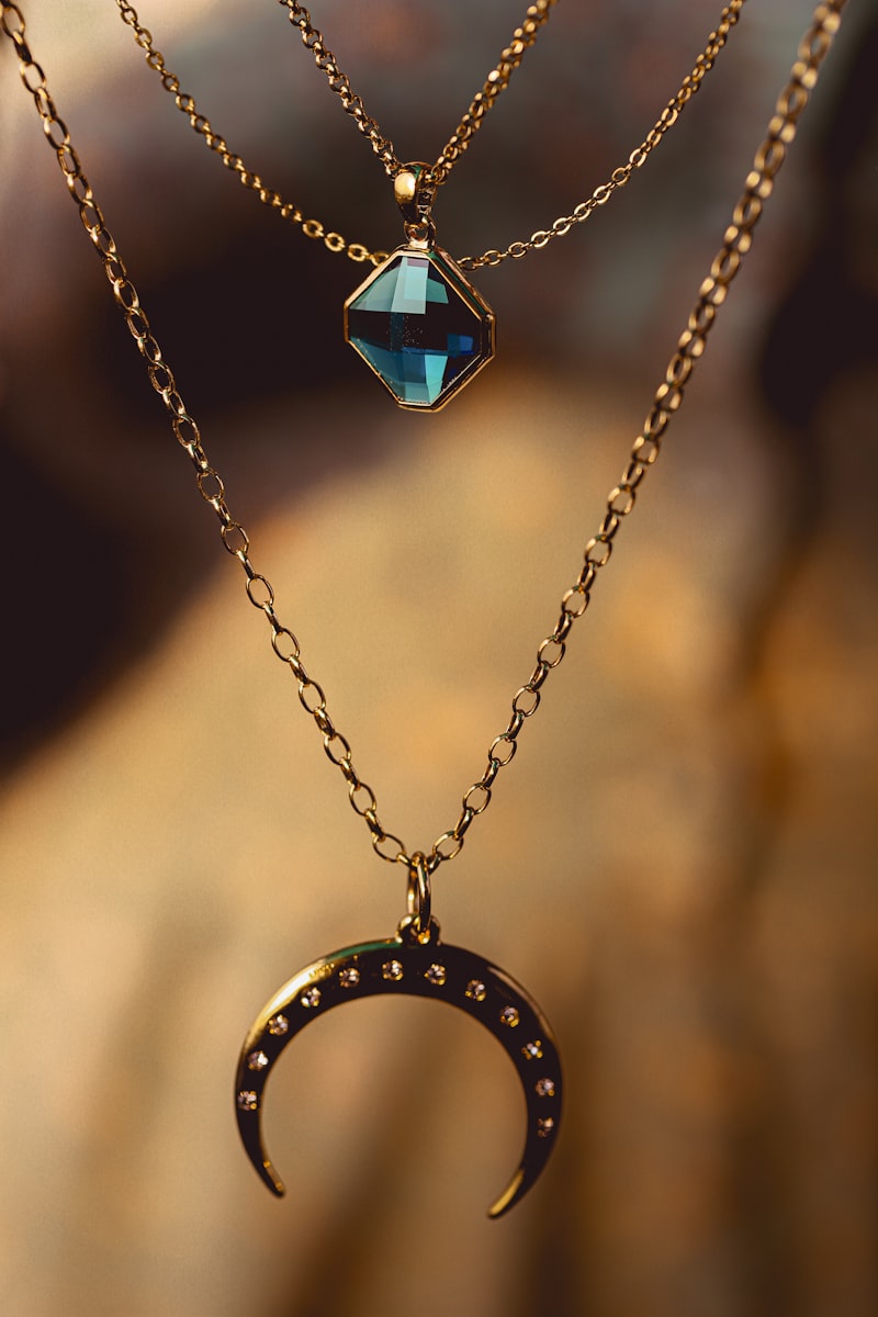 Layered gold necklaces with crescent and gemstone pendants