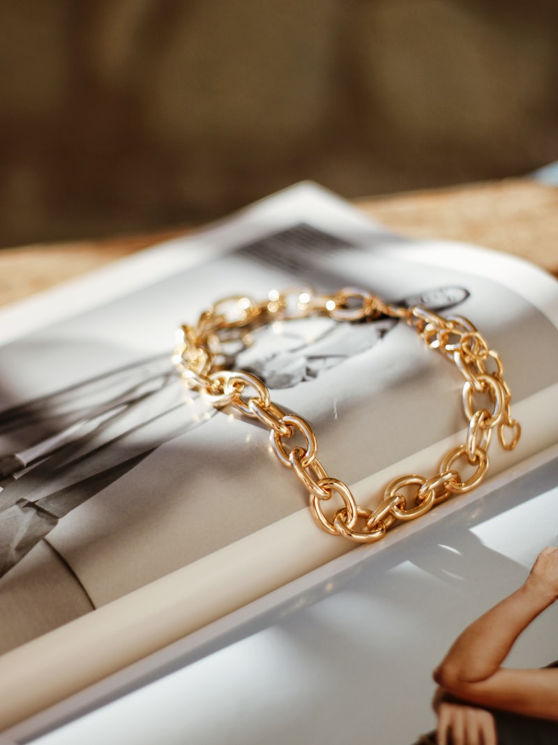 Chunky gold chain-link bracelet on an open book