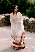 Woman in an ivory embroidered anarkali suit with sheer dupatta outdoors