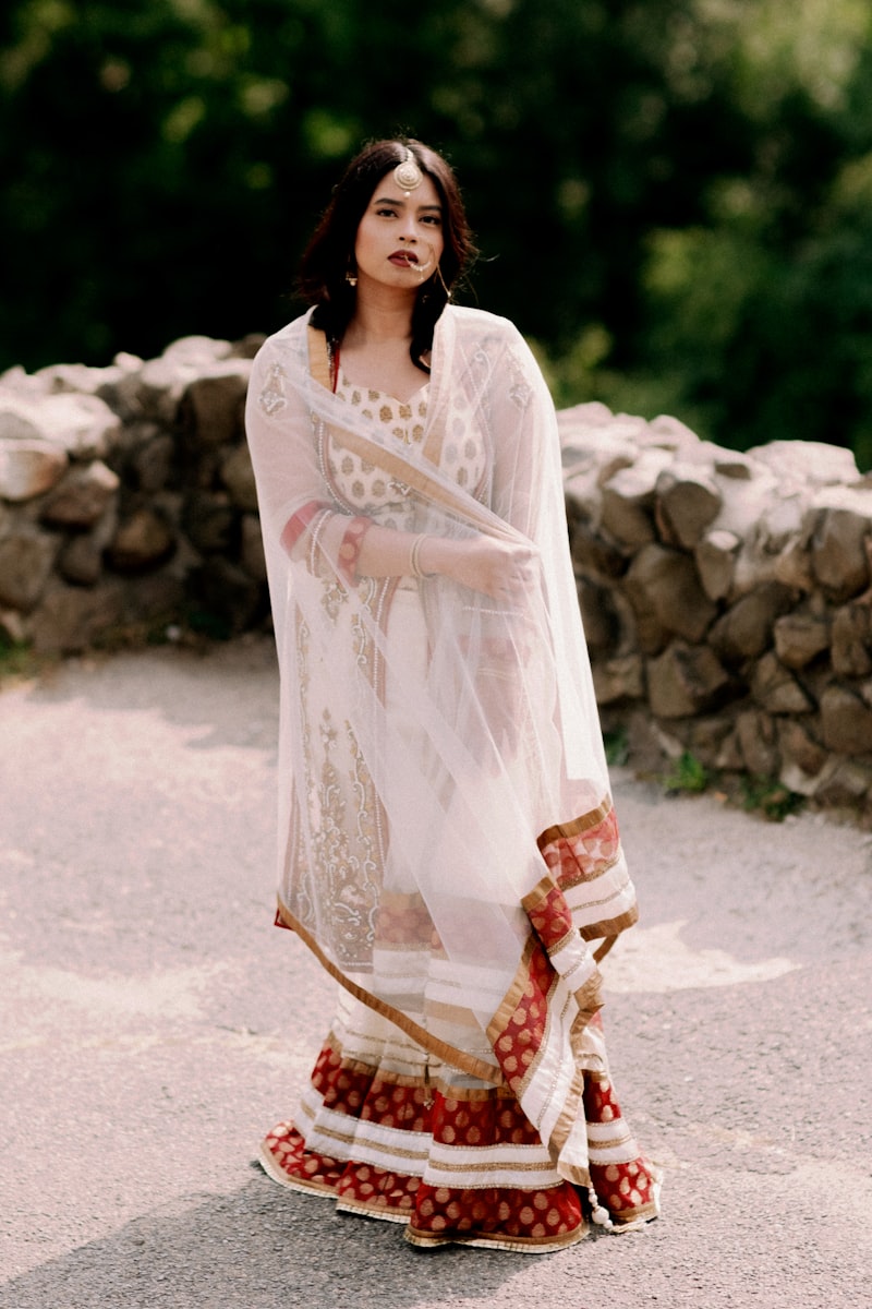 Woman in an ivory embroidered anarkali suit with sheer dupatta outdoors