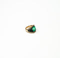 Emerald green cocktail ring in gold on white background