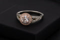 Rose-gold halo solitaire ring on a dark jewellery box