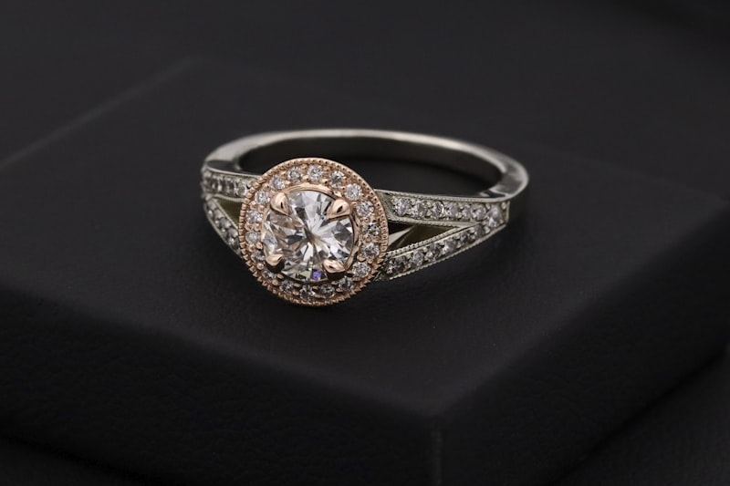 Rose-gold halo solitaire ring on a dark jewellery box