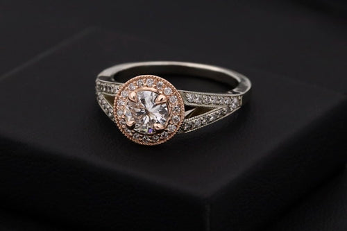 Rose-gold halo solitaire ring on a dark jewellery box
