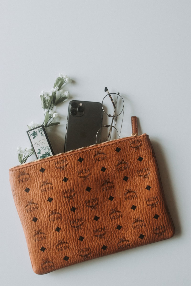 Silver glitter box clutch styled with flowers on a pale surface